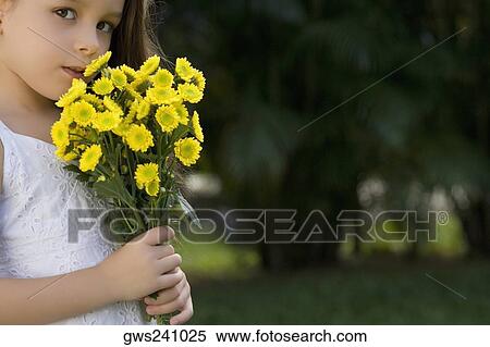 Stock Photography - Portrait of a girl holding a bunch of flowers. Fotosearch