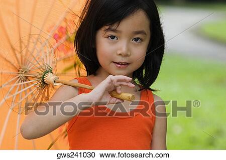 Stock Image - Portrait of a girl holding a parasol. Fotosearch