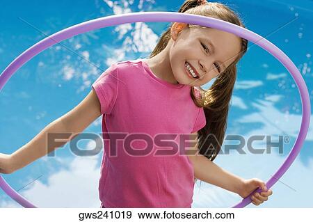 Portrait of a girl holding a plastic hoop and smiling View Large Photo Image Stock Photo - Portrait of a girl holding a plastic hoop and smiling. Fotosearch
