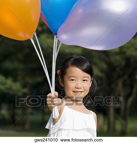 Portrait of a girl holding balloons and smiling View Large Photo Image Stock Image - Portrait of a girl holding balloons and smiling. Fotosearch