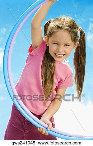 Portrait of a girl playing with two plastic hoops View Large Photo Image Stock Photography - Portrait of a girl playing with two plastic hoops. Fotosearch