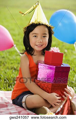 Portrait of a girl with holding a stack of birthday gifts and smiling in a park View Large Photo Image Stock Photo - Portrait of a girl with holding a stack of birthday gifts and smiling in a park. Fotosearch