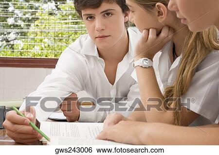 Close-up of school students studying together in a classroom View Large Photo Image Stock Photograph - Close-up of school students studying together in a classroom. Fotosearch