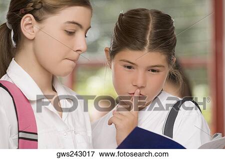 Close-up of two schoolgirls looking at a textbook View Large Photo Image Stock Photo - Close-up of two schoolgirls looking at a textbook. Fotosearch