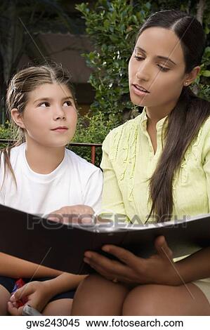 Female teacher checking a file of a schoolgirl View Large Photo Image Stock Photography - Female teacher checking a file of a schoolgirl. Fotosearch