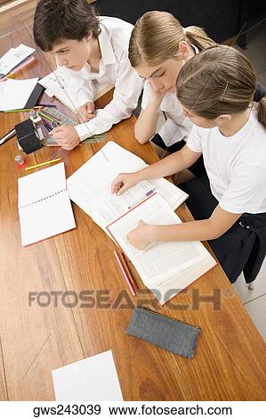 High angle view of two schoolgirls and a schoolboy studying in a classroom View Large Photo Image Stock Photo - High angle view of two schoolgirls and a schoolboy studying in a classroom. Fotosearch