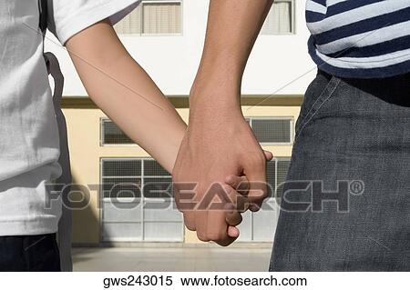 Stock Photography - Mid section view of a boy holding hands of his sister. Fotosearch