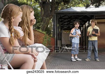 Stock Photography - Side profile of two schoolgirls looking at two schoolboys. Fotosearch