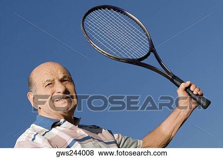 Close-up of a senior man holding a tennis racket View Large Photo Image Stock Photo - Close-up of a senior man holding a tennis racket. Fotosearch
