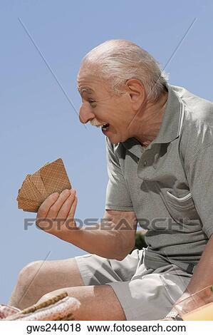 Stock Photo - Close-up of a senior man playing cards. Fotosearch
