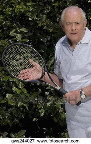Portrait of a senior man holding a tennis racket View Large Photo Image Stock Photo - Portrait of a senior man holding a tennis racket. Fotosearch