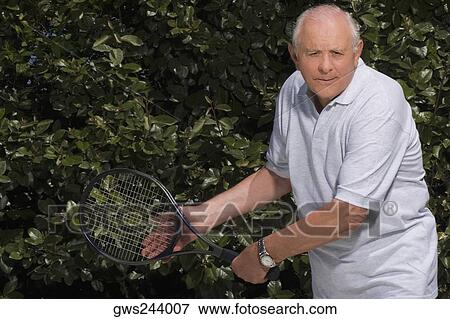 Stock Photo - Senior man playing tennis. Fotosearch
