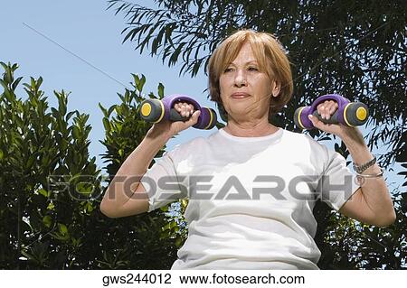Senior woman exercising with dumbbells View Large Photo Image Stock Image - Senior woman exercising with dumbbells. Fotosearch