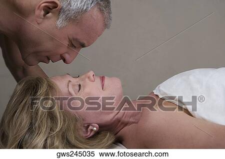 Close-up of a mature woman lying on a massage table with a senior man looking at her face View Large Photo Image Stock Photography - Close-up of a mature woman lying on a massage table with a senior man looking at her face. Fotosearch