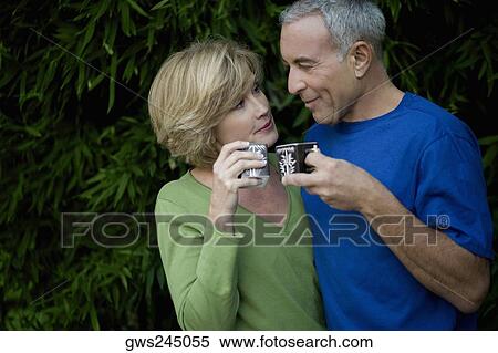 Close-up of a senior man with a mature woman holding tea cups and looking at each other View Large Photo Image Stock Photography - Close-up of a senior man with a mature woman holding tea cups and looking at each other. Fotosearch