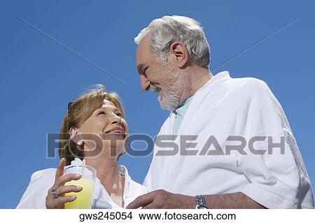 Low angle view of a senior couple looking at each other and smiling View Large Photo Image Picture - Low angle view of a senior couple looking at each other and smiling. Fotosearch