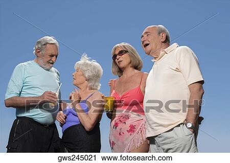 Low angle view of two senior couples standing together View Large Photo Image Stock Image - Low angle view of two senior couples standing together. Fotosearch