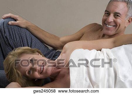 Portrait of a mature woman lying down with a senior man smiling behind her View Large Photo Image Stock Photo - Portrait of a mature woman lying down with a senior man smiling behind her. Fotosearch