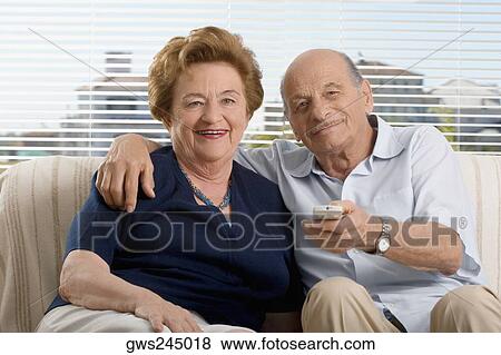 Portrait of a senior couple watching television View Large Photo Image Stock Photo - Portrait of a senior couple watching television. Fotosearch