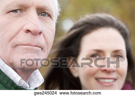 Portrait of a senior man with a mature woman smiling behind him View Large Photo Image Picture - Portrait of a senior man with a mature woman smiling behind him. Fotosearch
