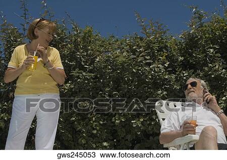 Senior couple holding glasses of juice View Large Photo Image Stock Image - Senior couple holding glasses of juice. Fotosearch