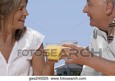 Senior couple holding glasses of juice View Large Photo Image Stock Photography - Senior couple holding glasses of juice. Fotosearch