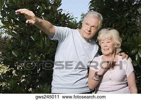 Senior couple standing in a garden View Large Photo Image Stock Image - Senior couple standing in a garden. Fotosearch