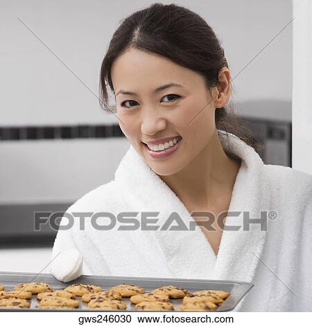Portrait of a young woman holding a tray of cookies and smiling View Large Photo Image Stock Image - Portrait of a young woman holding a tray of cookies and smiling. Fotosearch