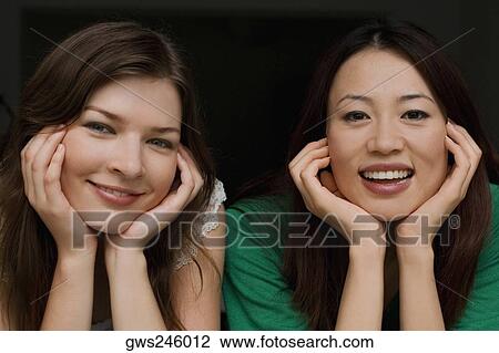 Stock Image - Portrait of two young women smiling. Fotosearch