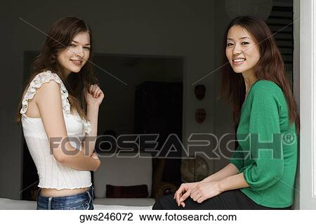 Side profile of two young women smiling View Large Photo Image Stock Image - Side profile of two young women smiling. Fotosearch