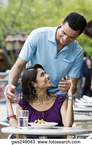 Couple looking at each other and smiling at a sidewalk cafe View Large Photo Image Stock Image - Couple looking at each other and smiling at a sidewalk cafe. Fotosearch