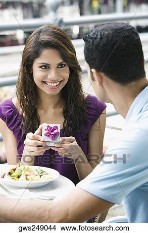 Mid adult man proposing to a young woman at a sidewalk cafe View Large Photo Image Picture - Mid adult man proposing to a young woman at a sidewalk cafe. Fotosearch