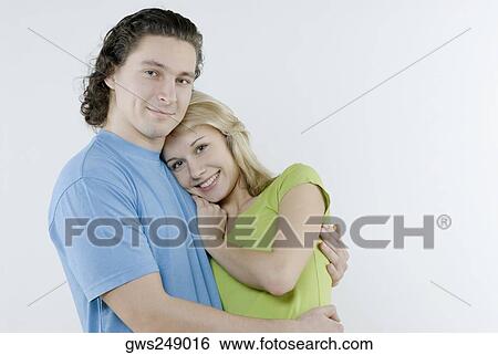 Portrait of a young couple embracing each other View Large Photo Image Stock Photograph - Portrait of a young couple embracing each other. Fotosearch