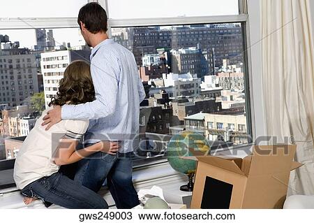 Rear view of a young man looking out through a window View Large Photo Image Stock Image - Rear view of a young man looking out through a window. Fotosearch