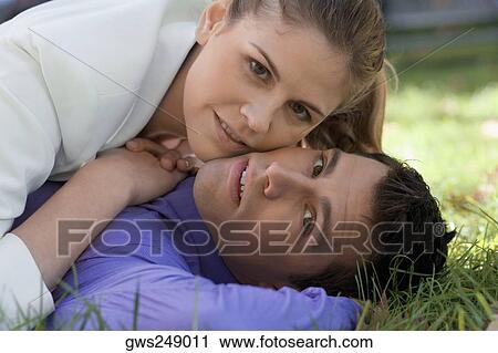 Young couple romancing in a park View Large Photo Image Stock Image - Young couple romancing in a park. Fotosearch