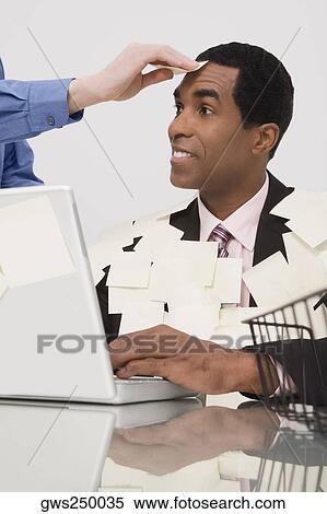 Businessman working on a laptop and covering with adhesive notes View Large Photo Image Stock Photography - Businessman working on a laptop and covering with adhesive notes. Fotosearch