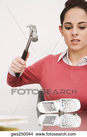 Businesswoman breaking a mobile phone with a hammer View Large Photo Image Picture - Businesswoman breaking a mobile phone with a hammer. Fotosearch