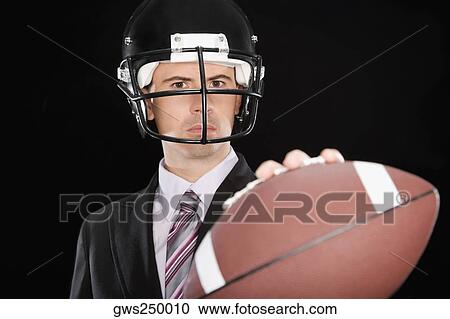Close-up of a businessman wearing a football helmet View Large Photo Image Stock Image - Close-up of a businessman wearing a football helmet. Fotosearch