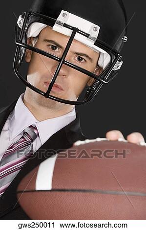 Close-up of a businessman wearing a football helmet View Large Photo Image Stock Image - Close-up of a businessman wearing a football helmet. Fotosearch