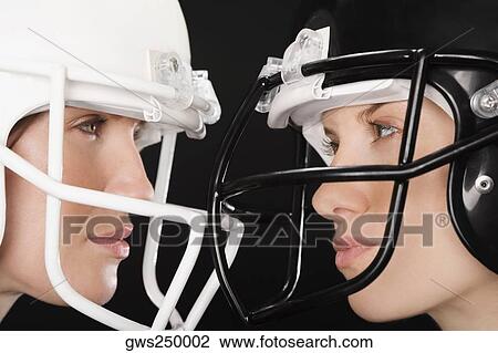 Close-up of two businesswomen wearing football helmets and looking at each other View Large Photo Image Stock Image - Close-up of two businesswomen wearing football helmets and looking at each other. Fotosearch
