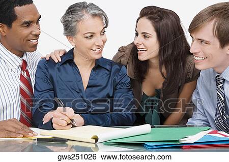 Stock Photograph - Business executives sitting in a conference room and smiling. Fotosearch