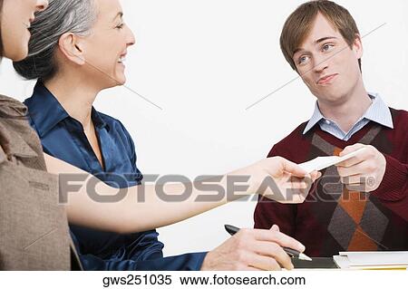 Businessman giving a paper to a businesswoman View Large Photo Image Stock Photography - Businessman giving a paper to a businesswoman. Fotosearch