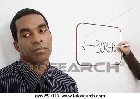 Stock Photo - Businessman thinking with a person's hand writing on a whiteboard. Fotosearch