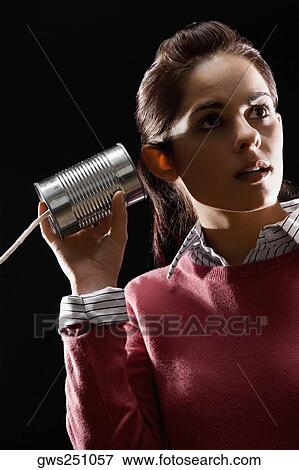 Stock Photo - Businesswoman using tin can phone. Fotosearch
