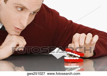 Close-up of a businessman looking at dentures View Large Photo Image Stock Photo - Close-up of a businessman looking at dentures. Fotosearch