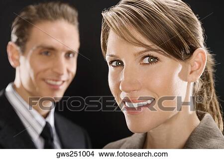 Portrait of a businesswoman with a businessman behind her View Large Photo Image Picture - Portrait of a businesswoman with a businessman behind her. Fotosearch