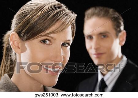 Portrait of a businesswoman with a businessman behind her View Large Photo Image Stock Image - Portrait of a businesswoman with a businessman behind her. Fotosearch