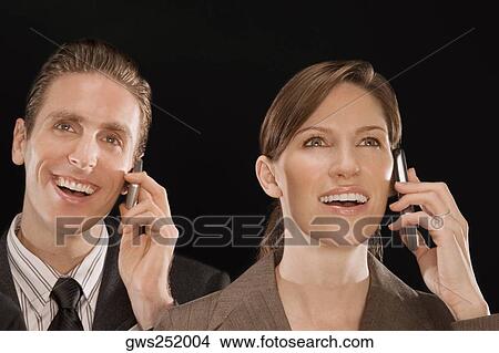 Business executives talking on mobile phones and smiling View Large Photo Image Picture - Business executives talking on mobile phones and smiling. Fotosearch