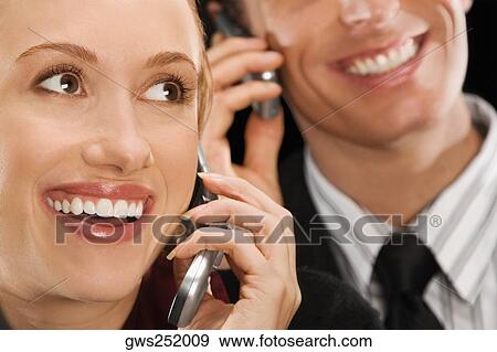 Business executives talking on mobile phones and smiling View Large Photo Image Stock Photo - Business executives talking on mobile phones and smiling. Fotosearch