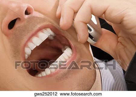 Stock Image - Close-up of a businessman shouting on a mobile phone. Fotosearch